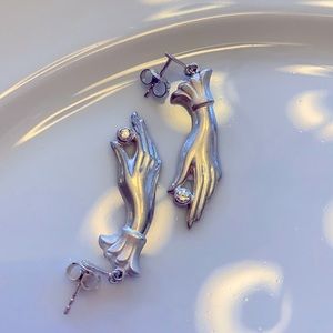 Vintage earrings of a hand holding a “diamond”